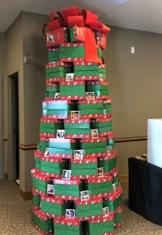 a christmas tree made out of boxes and wrapped in red and green paper with pictures on them