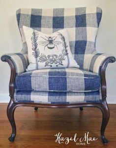 a blue and white checkered chair with a bee pillow on it's back