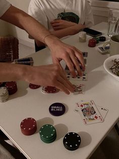 two people are playing cards on a table