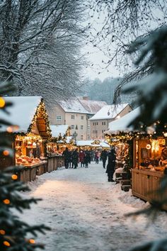 people walking down a snowy street lined with christmas decorations