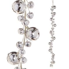 a pair of silver bells hanging from a metal rod with beads attached to the end