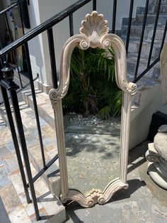 a mirror sitting on top of a stone floor next to a stair case and railing