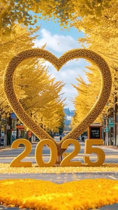 a heart - shaped sculpture in the middle of a street with trees and yellow leaves