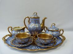 a blue and gold tea set sitting on top of a tray