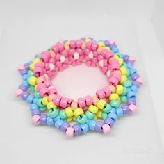 multicolored beads are arranged in the shape of a circle on a white surface