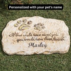 personalized pet memorial stone with dog's paw prints on it in the grass