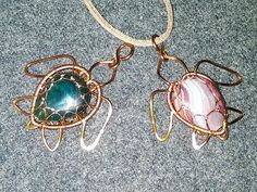 two pendants with wire wrapped around them sitting on a carpeted floor next to each other