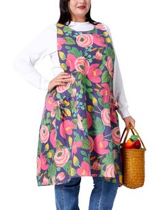 a woman is holding a basket full of fruit and wearing an apron with flowers on it