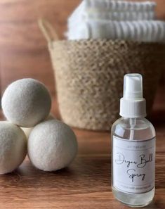 three white balls sitting next to a bottle of deodorant spray on a wooden table