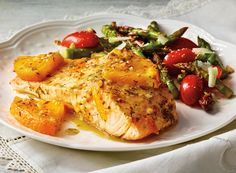 a white plate topped with fish and vegetables