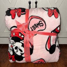 two mickey mouse blankets wrapped in pink ribbon