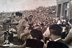 an old black and white photo of a man giving a speech to a large crowd