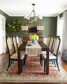 a dining room table with chairs and a rug on the floor in front of it