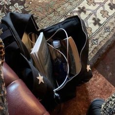 an open book bag sitting on top of a couch next to a brown leather chair