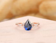 a blue and white diamond ring sitting on top of a table