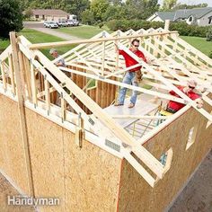 two men standing on the roof of a house under construction