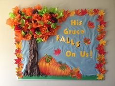 a bulletin board decorated with fall leaves and a pumpkin under a tree that reads his grace falls on us