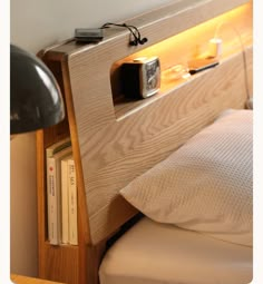 a bed with a wooden headboard and night stand next to a lamp on the wall