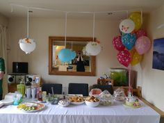 a table is set up with balloons and food