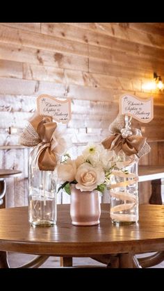 two vases with flowers are sitting on a table