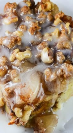 a plate topped with dessert covered in icing and walnuts on top of it