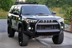 a black toyota truck is parked on the side of the road