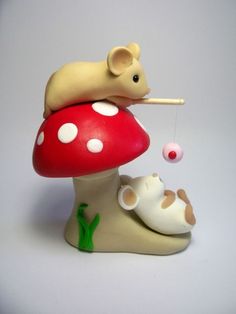 a toy mouse sitting on top of a mushroom