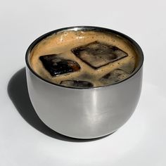 a cup of coffee with ice cubes in it