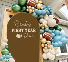 balloons and footballs decorate the front door of a house for a first year party