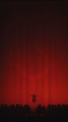 the silhouette of a person standing in front of a red curtain