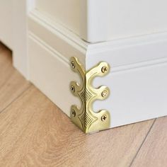 a close up of a door handle on a wooden floor with white trim and wood floors