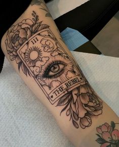 a woman's arm with an eye and flowers on it, which reads the reader