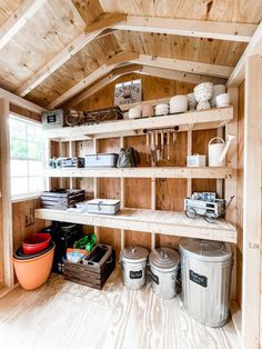 the inside of a shed with shelves and buckets