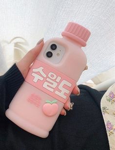 a person holding a pink phone case with an apple on it