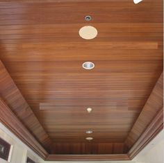 the ceiling is lined with wooden planks and round lights