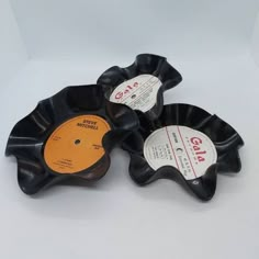 three records are sitting on top of each other, one is black and the other is orange