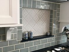 a stove top oven sitting inside of a kitchen next to a wall mounted faucet