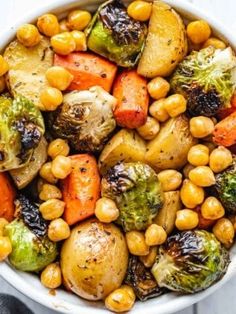 a white bowl filled with vegetables and chickpeas