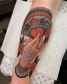 a person with a tattoo on their arm holding a heart