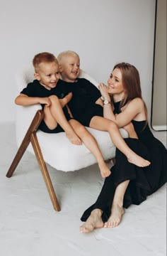 two adults and a child sitting on a chair