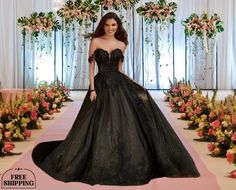 a woman in a black dress standing on a pink and white carpet with flowers behind her