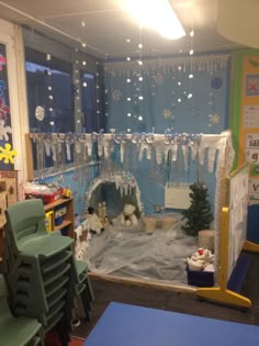 an indoor play area with snow and ice in the middle, surrounded by plastic chairs