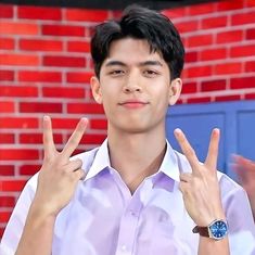 a young man making the peace sign with his hands