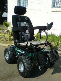 a large wheel chair sitting on the side of a road in front of a house