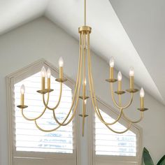 a chandelier hanging from the ceiling in a room with white walls and windows