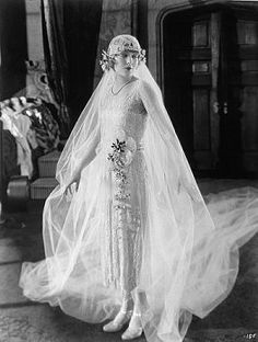 an old black and white photo of a woman in a wedding dress with veil over her head