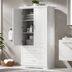 a white bathroom cabinet with drawers and towels on top of the shelf next to it