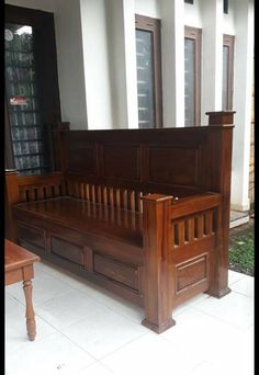 a wooden bench sitting in front of a window next to a white tiled floor and wall