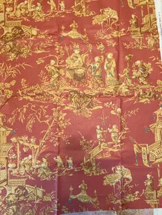 an old red and gold cloth with pictures on it