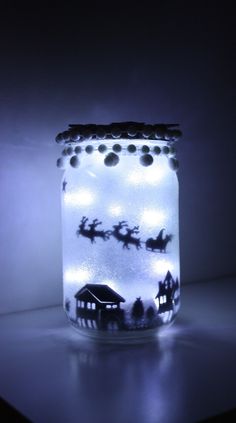 a lighted jar with santa's sleighs on it and lights inside